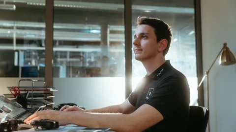 AVL employee in front of laptop