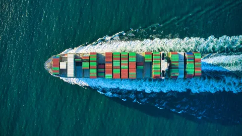 a large cargo ship with colorful containers seen from a birds eys perspective