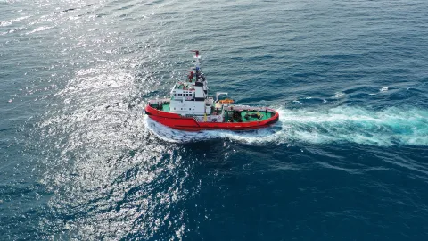 small red workboat from above