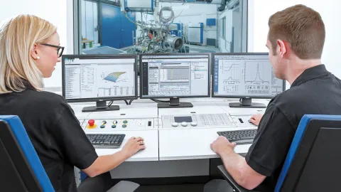 Two operators sitting infront of an engine testbed