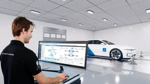 Man standing at a trolley operating vehicle automation software