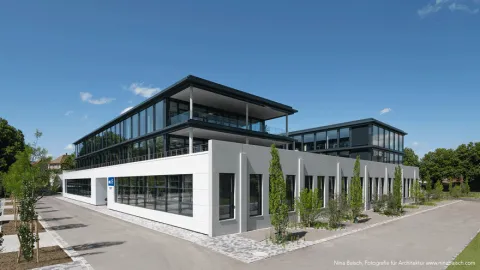 AVL engineering facility building with modern glass façade, landscaped outdoor area and office spaces in daylight