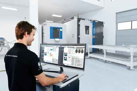 Man standing at a trolley operating battery automation software