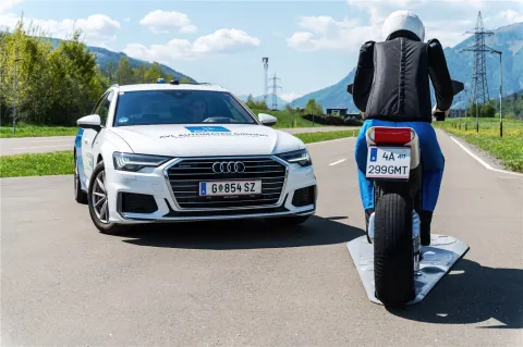Car approaches motorcyclist