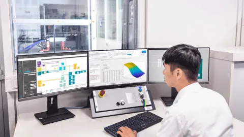 Engineer operating AVL inverter test system via multi-screen workstation in laboratory environment with data visualization and control interface